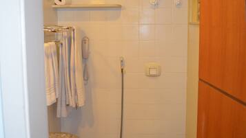 Un baño pequeño con inodoro, ducha y lavabo.