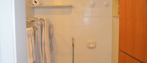 Un baño pequeño con inodoro, ducha y lavabo.