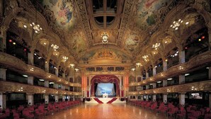 En pragtfuld teatersal med detaljeret arkitektur, flere balkoner og en central scene.
