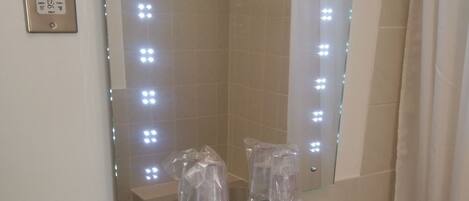 A bathroom with a sink, mirror, and lights.