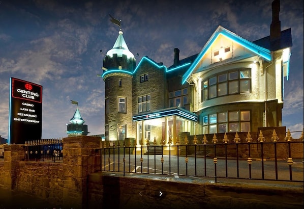 Un grand bâtiment historique, doté d’une tour imposante et d’une enseigne indiquant le « Genting Club ».