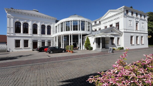 A historic building with a central rotunda, a covered entrance, and a classic facade. - Hotel Am Schloss Aurich (Aurich)