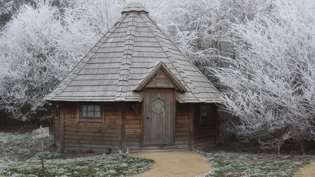 A wooden cabin with a gabled roof and a central door, surrounded by frosted trees. - Domaine de la Boulaie (Treize-Vents)