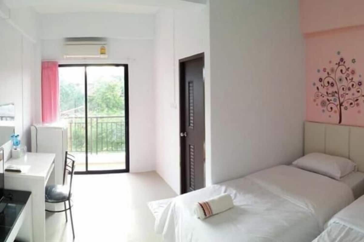 Una habitación de hotel con una cama, un escritorio y vistas al exterior.