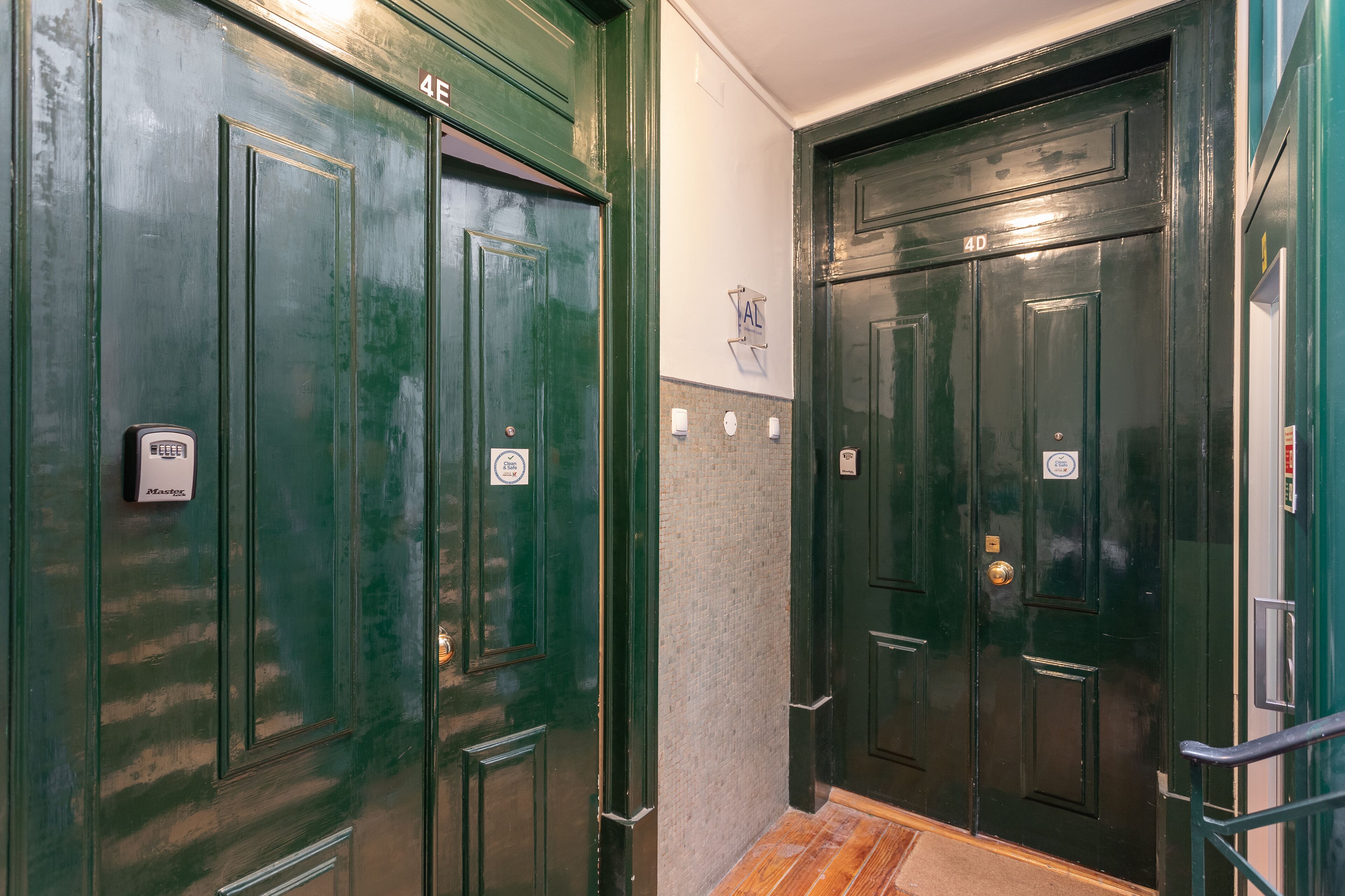 Two green doors with a small sign above each door.