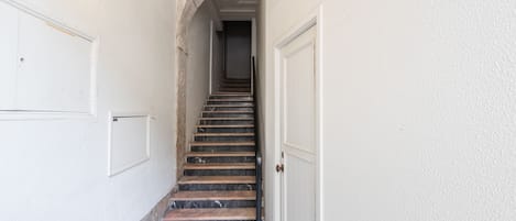 Una escalera con un arco de piedra que conduce a una puerta.