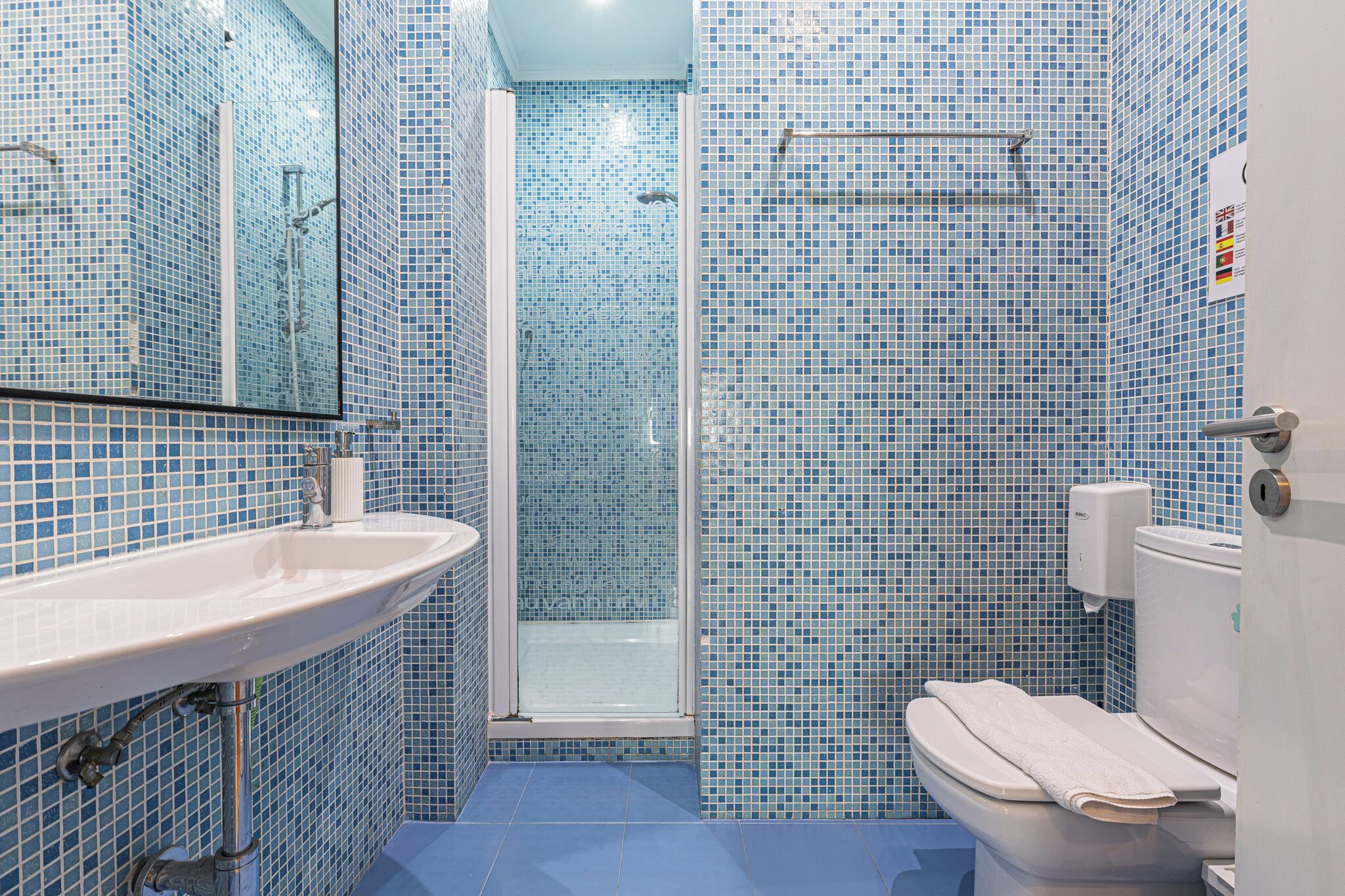 Un baño con lavamanos, inodoro y ducha.