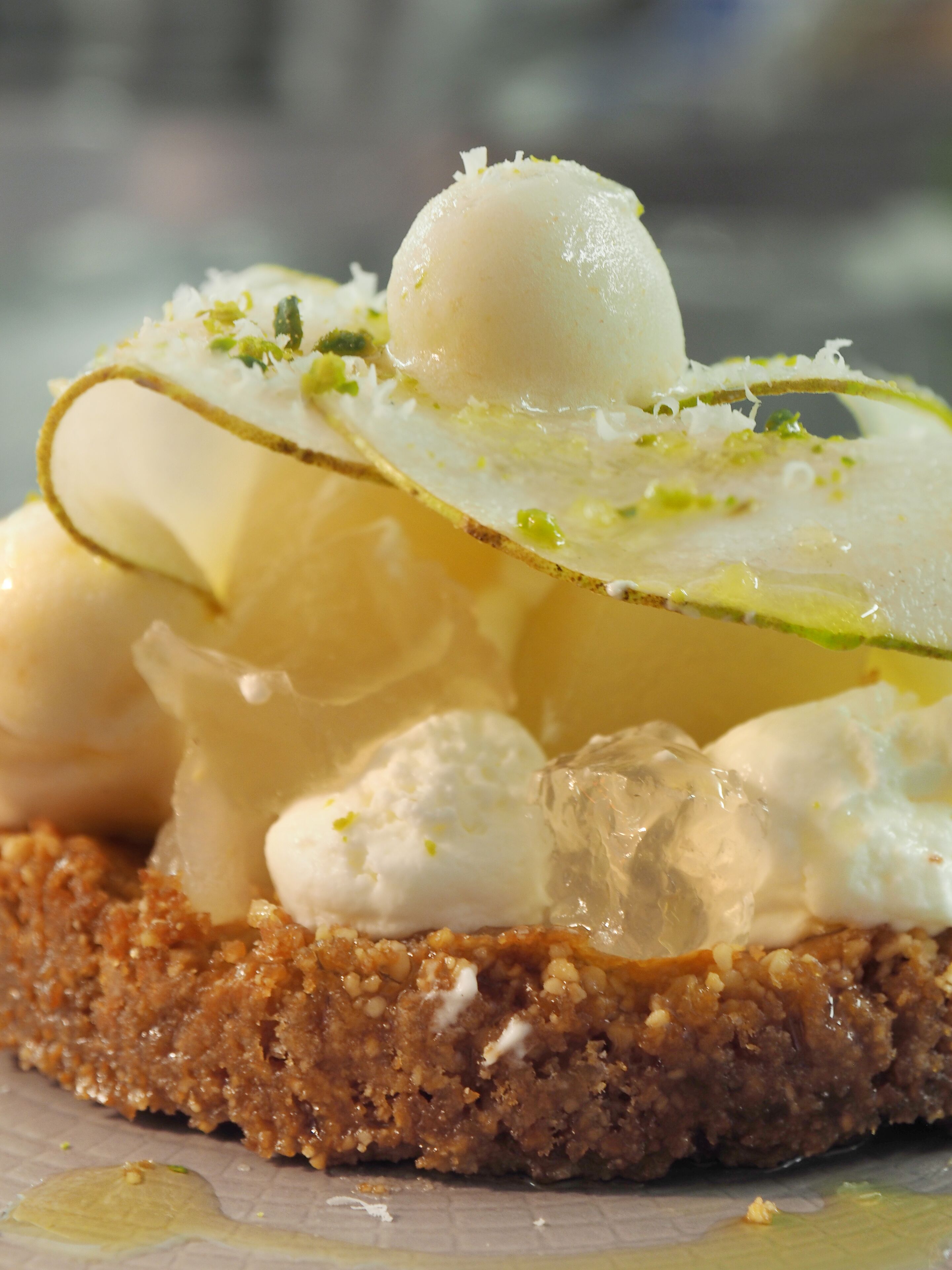 Un dessert surmonté d’une crème onctueuse, d’une tranche de citron et décoré d’herbes fraîches.