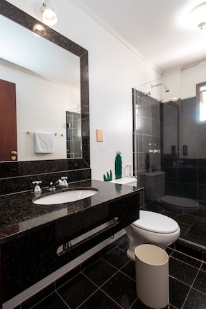 A modern bathroom with a black marble sink, a white toilet, and a glass-enclosed shower. - ibis Styles Presidente Prudente Portal D'Oeste (Presidente Prudente)