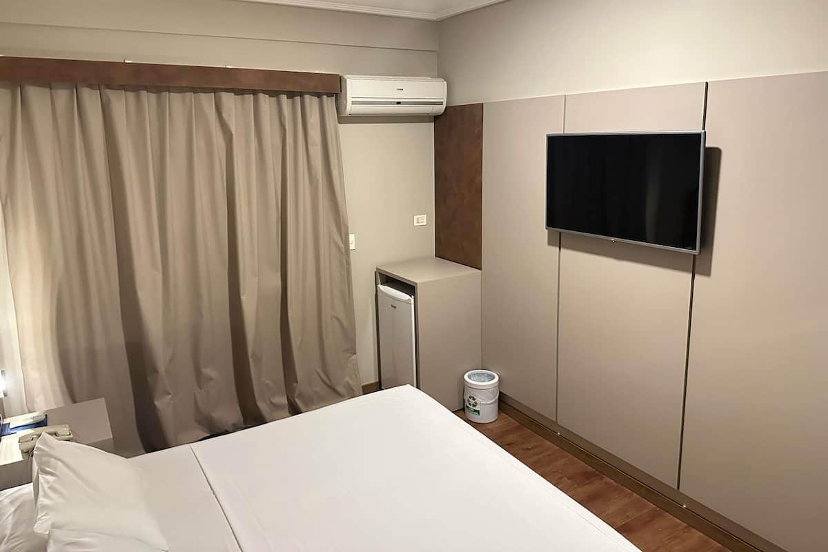 Suíte executiva, 1 cama King | Frigobar, Wi-Fi de cortesia, roupa de cama