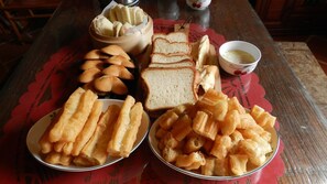 A table with various food items including bread, pastries, and a bowl of soup. - Pearl B&B (Jinsha)