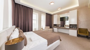 A modern hotel room with a large bed, a desk area, and a television. - Wish Aqua & Spa Resort (Vyshen'ky)