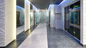 A modern hotel corridor with tiled floors, glass doors, and a patterned wall design. - Wish Aqua & Spa Resort (Vyshen'ky)
