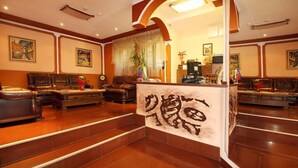 A spacious lobby with leather sofas, a reception desk, and artwork on the walls. - Alafrangite Hotel (Plovdiv)