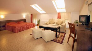 A room with a bed, a sofa, a coffee table, and a TV. - Alafrangite Hotel (Plovdiv)