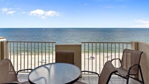 Ein Balkon mit Blick auf den Strand und das Meer.