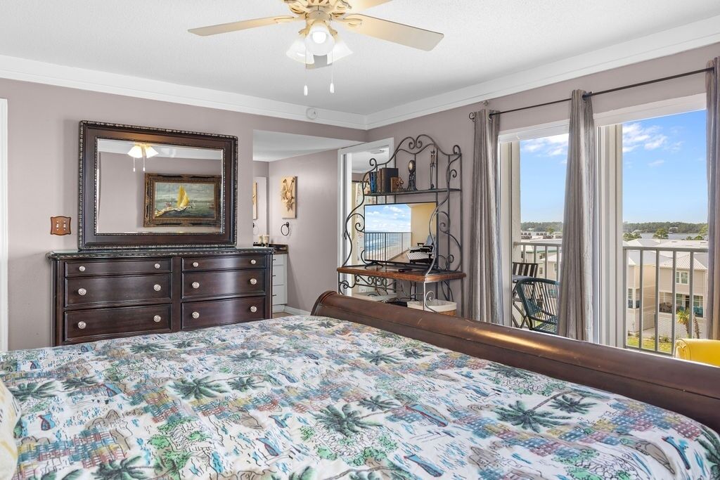 Une chambre dotée d’un grand lit, d’une commode, d’un miroir, d’un bureau avec une chaise et d’un balcon offrant une vue agréable.