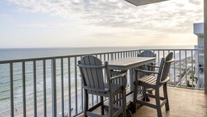 Un balcon avec une table et des chaises donnant sur l’océan.