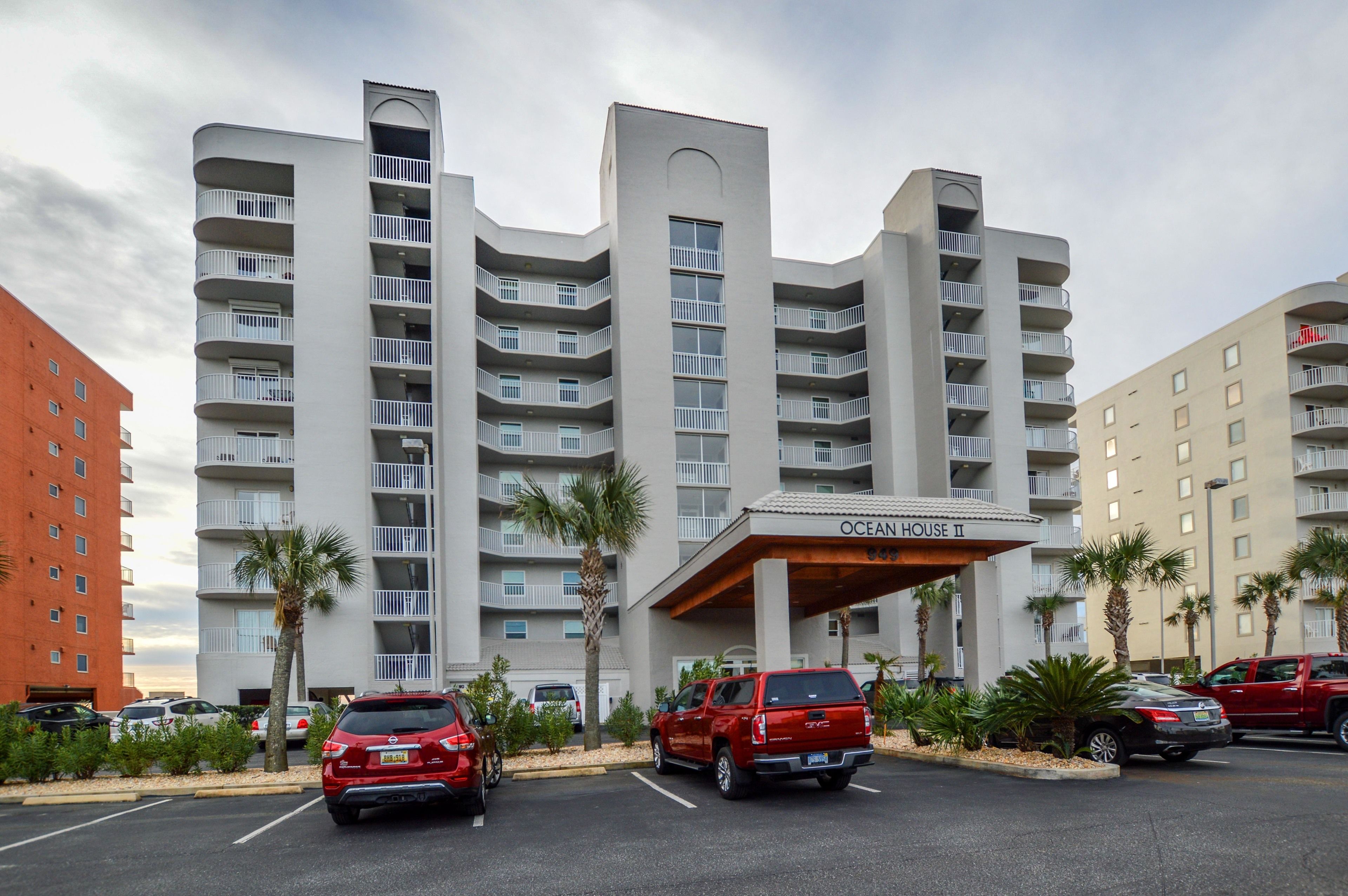 Un hôtel à plusieurs étages, doté d’un design moderne, avec des balcons et une entrée imposante portant l’inscription « OCEAN HOUSE II ».