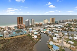 An aerial view of a coastal town with high-rise buildings, a marina, and a beach. - 214 Shoreland (Gulf Shores)