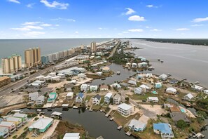 A coastal residential area with houses, a marina, and a road leading to the beach. - 214 Shoreland (Gulf Shores)