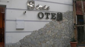 A hotel entrance with a stone wall and a sign that reads "Hotel OTE". - Sirin Hotel (Corum)