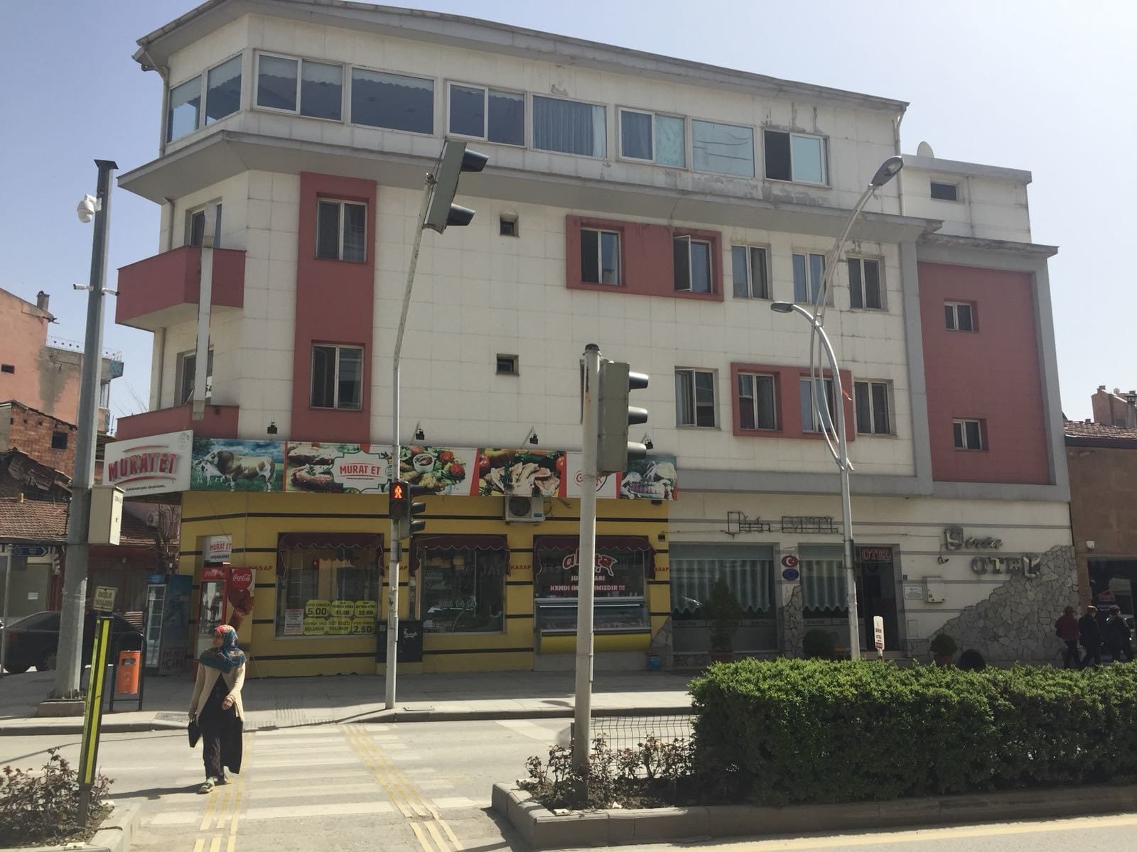 Un edificio de varios pisos con fachada amarilla y un letrero que dice "Murat Et".