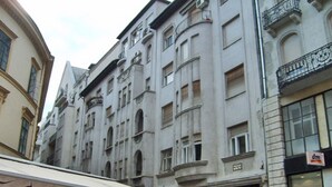 Un immeuble à plusieurs étages, de style architectural classique, caractérisé par des fenêtres en arc et des moulures décoratives.