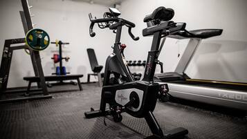 A stationary bike, a treadmill, and weightlifting equipment in a gym.