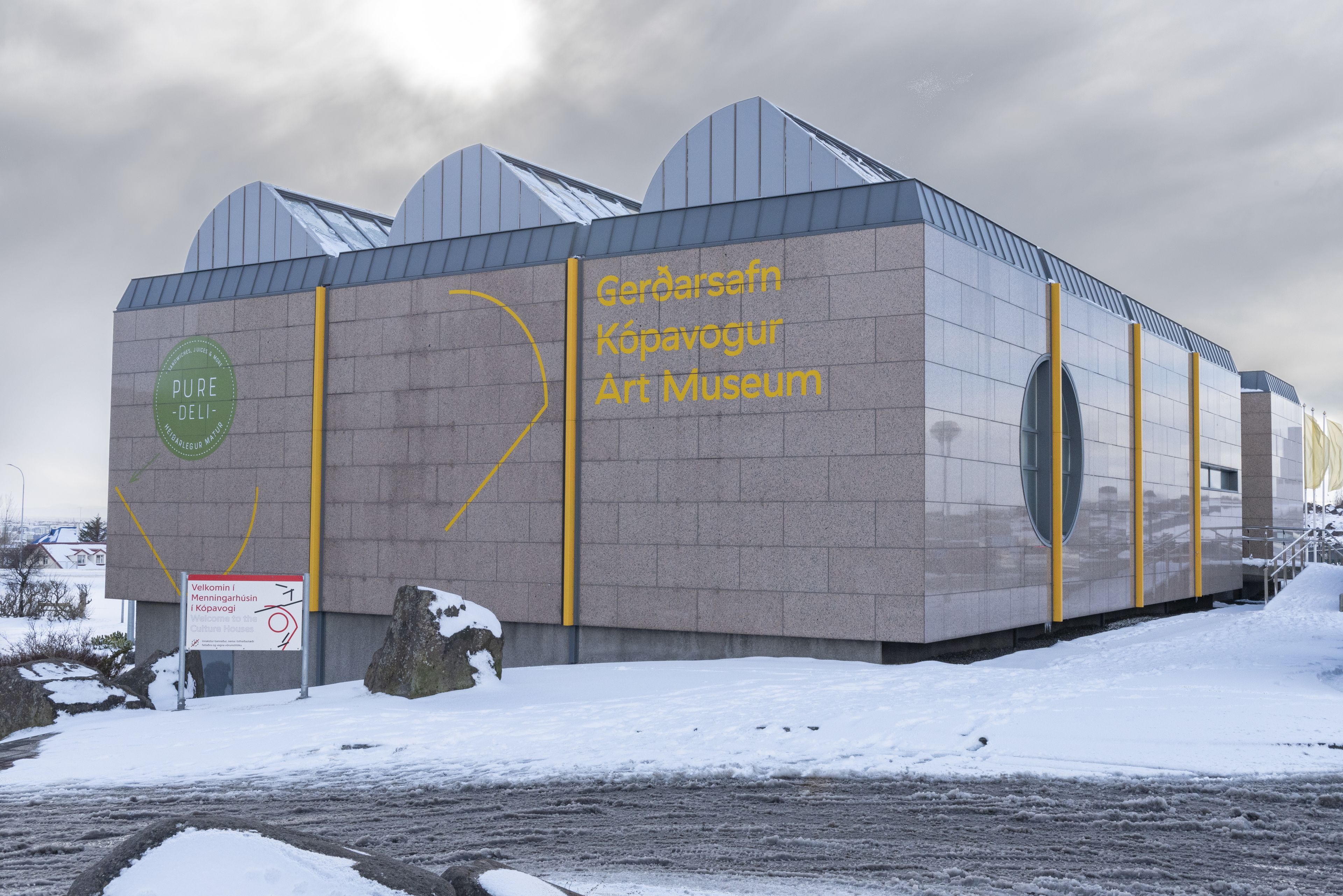 Een modern gebouw met een bord waarop staat: Gerdaarsafn Kópavogur Kunstmuseum.