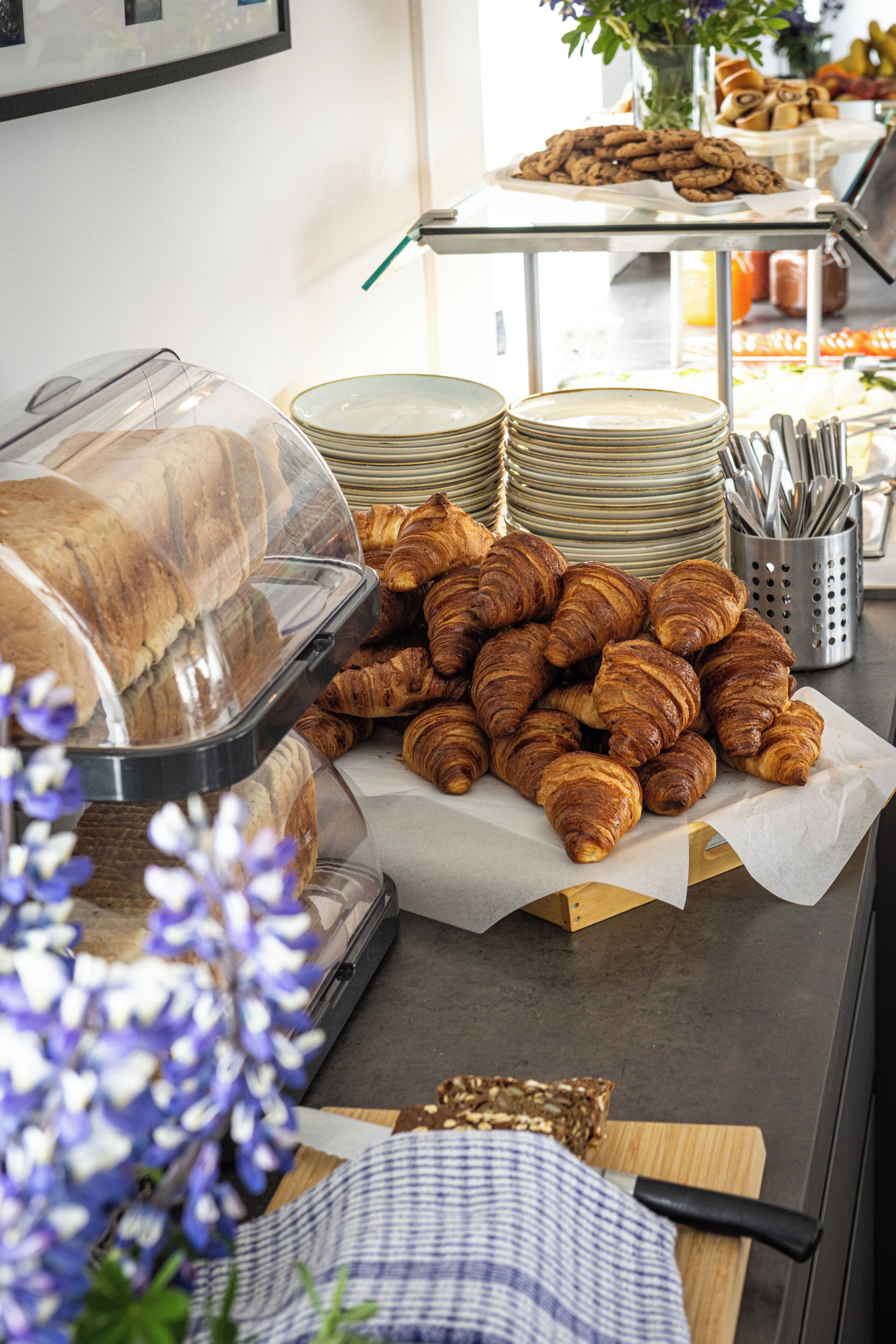 Un bufé de desayuno con cruasanes, pastelería y una variedad de platos.