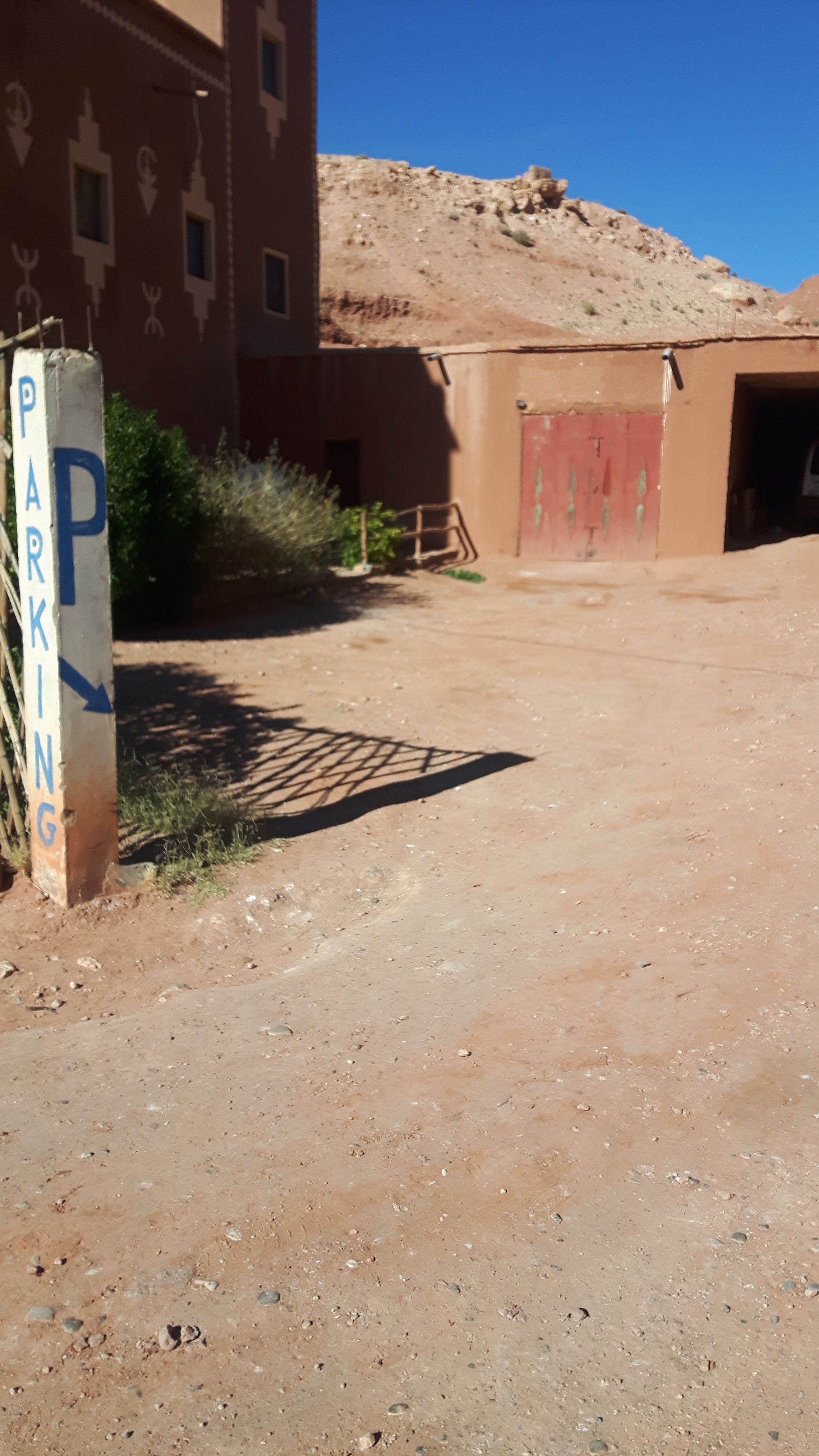 A parking area with a sign indicating 'PARKING' and a directional arrow.