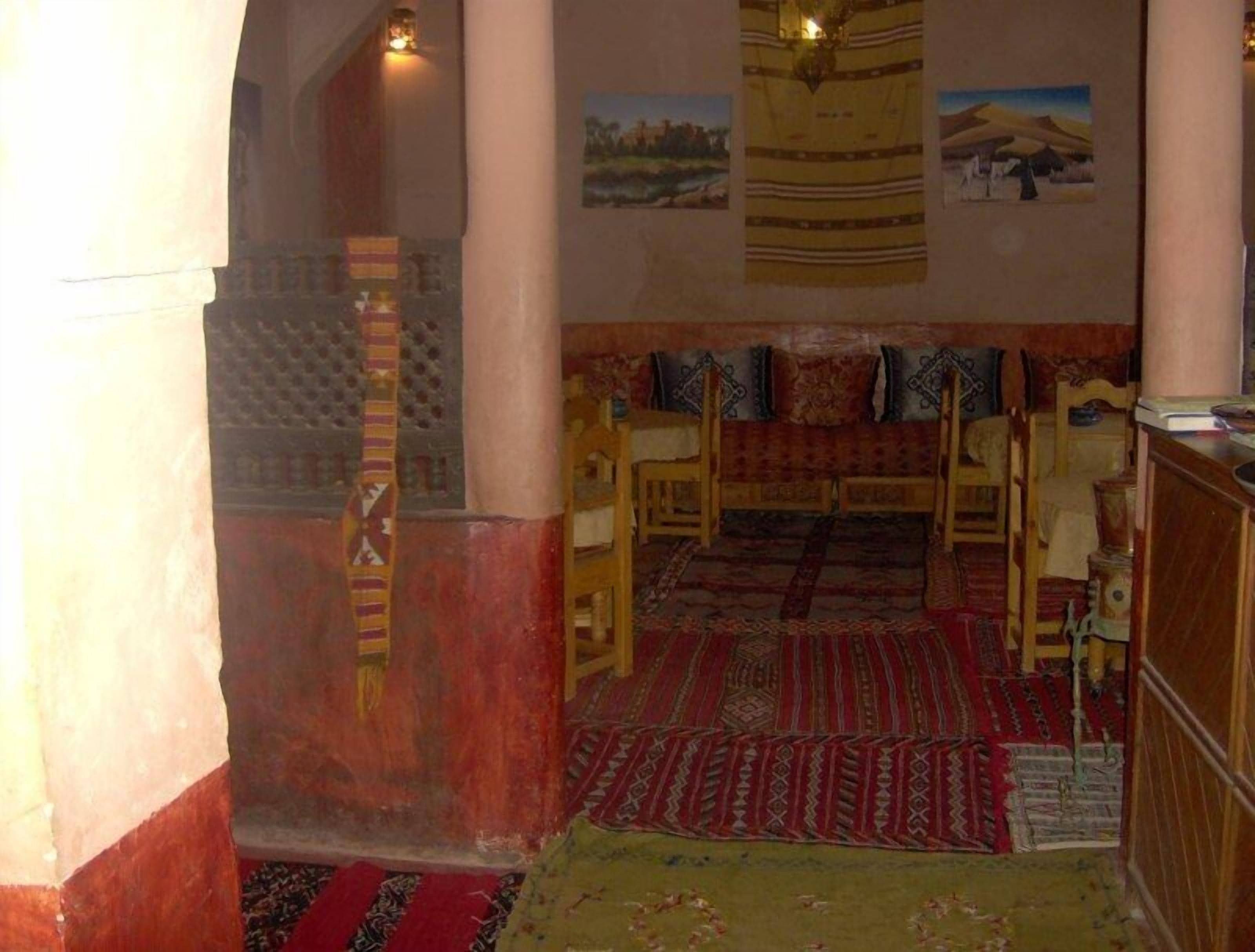 A traditional room with a sofa set, patterned rugs, and a wooden cabinet.
