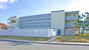 A multi-story building with a white exterior and a balcony on the second floor. - Eagle Bay 204 (Ocean City)