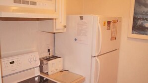 A compact kitchen with a stove, toaster, and refrigerator. - Eagle Bay 204 (Ocean City)