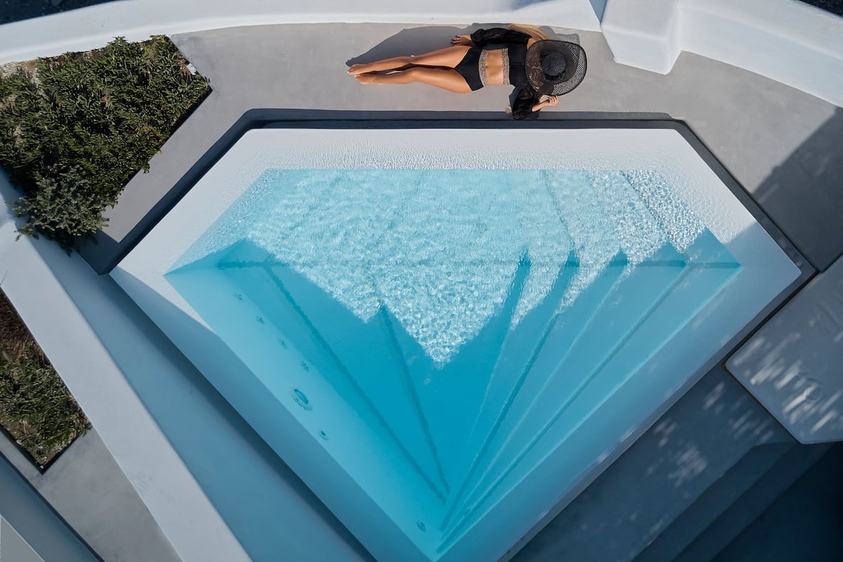 Un modèle de piscine au design géométrique unique, dotée d’un élément aquatique central et d’une série de marches d’accès.