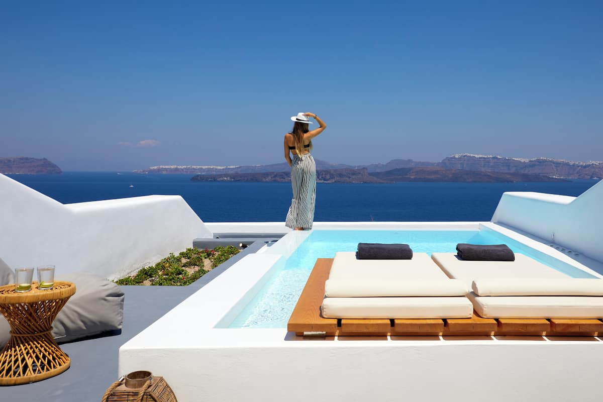 Une piscine sur le toit, dotée de chaises longues et offrant une vue sur la mer.