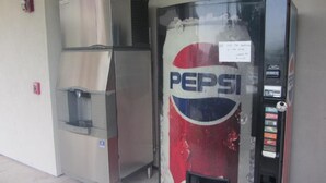 En automat med Pepsi-logo, møntåbning og en lille skærm.