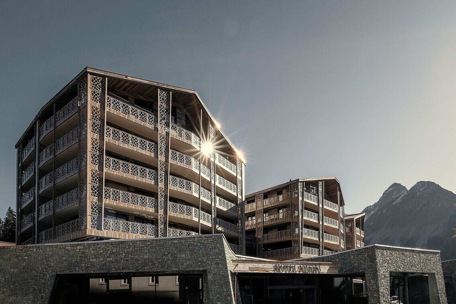 Un hotel a più piani con facciata in pietra e balconi.