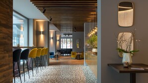 Een modern interieur met een patroonvloer, houten plafond en een zithoek met stoelen.