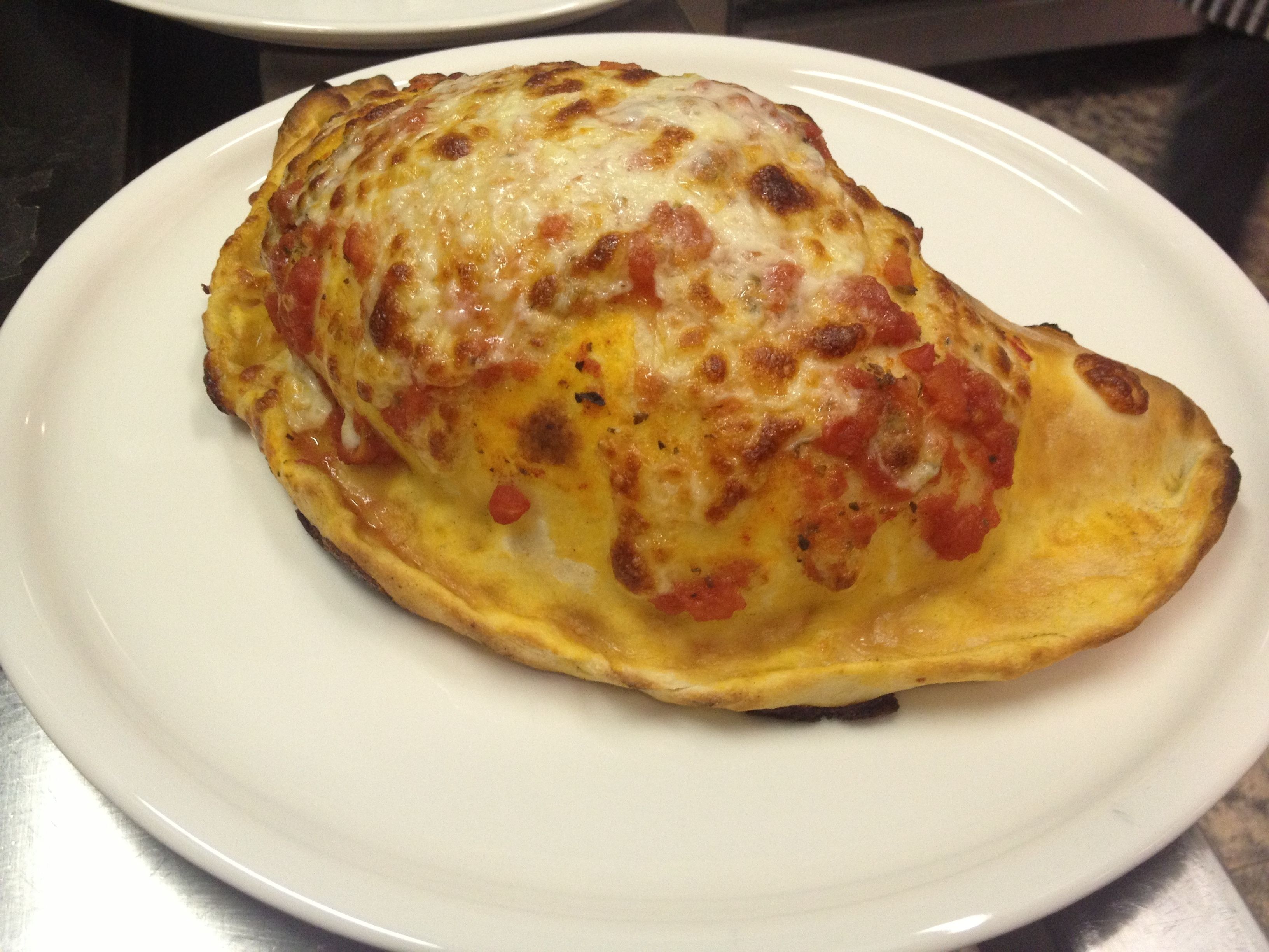 A single pizza on a white plate.