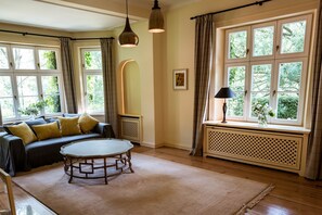 Un salon confortable avec un canapé, une table basse ronde et un radiateur.