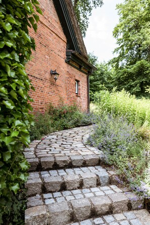 Un bâtiment en briques avec un chemin de pierre menant à une porte.