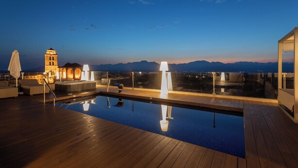 A rooftop pool with a view of mountains, a hot tub, and a lounge area. - Can Ribera By Zafiro (Muro)