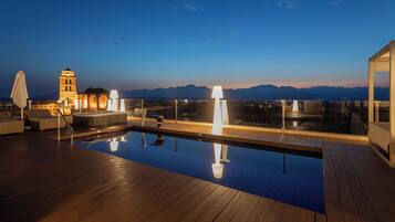 Una piscina al aire libre, sombrillas, tumbonas