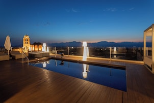 Piscina en la azotea con vistas a las montañas, un jacuzzi y un área de descanso.