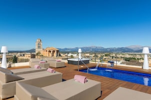 Una piscina al aire libre, sombrillas, tumbonas