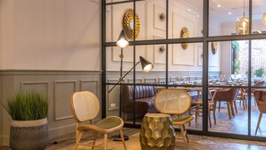 A modern interior with wicker chairs, a large potted plant, and a textured floor rug. - Can Ribera By Zafiro (Muro)