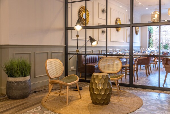A modern interior with wicker chairs, a large potted plant, and a textured floor rug. - Can Ribera By Zafiro (Muro)