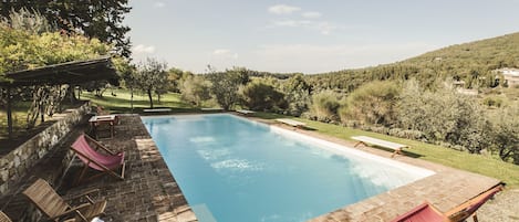 Una piscina al aire libre, tumbonas